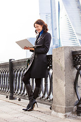 Image showing smiling middle-aged woman with a laptop