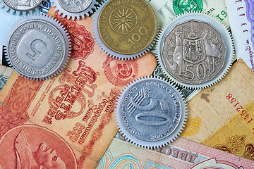 Image showing coin gear on the background of banknotes