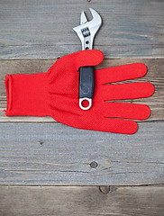 Image showing red glove and a pipe wrench