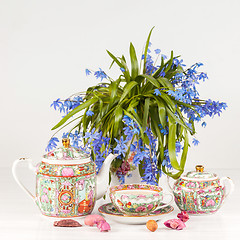 Image showing Tea with  lemon and bouquet of  blue primroses on the table