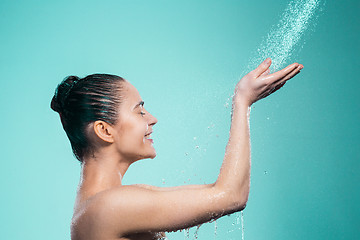 Image showing Woman enjoying water in the shower under a jet