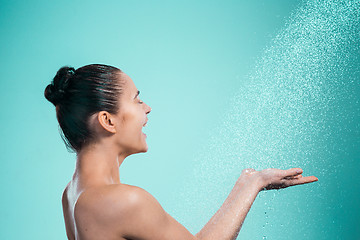 Image showing Woman enjoying water in the shower under a jet