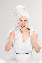 Image showing Young woman washing face with clean water