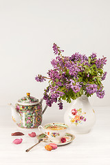 Image showing Tea with  lemon and bouquet of  lilac primroses on the table