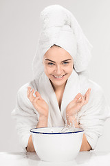 Image showing Young woman washing face with clean water