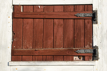 Image showing Weathered red plank window shutter