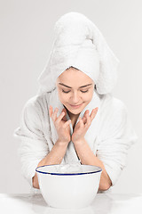 Image showing Young woman washing face with clean water