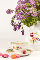 Image showing Tea with  lemon and bouquet of  lilac primroses on the table