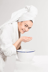 Image showing Young woman washing face with clean water
