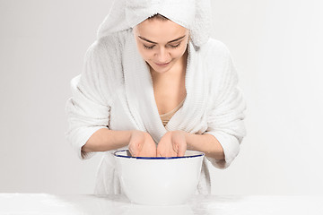 Image showing Young woman washing face with clean water