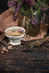 Image showing Tea with  lemon and bouquet of primroses on the table