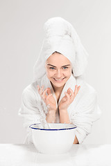 Image showing Young woman washing face with clean water