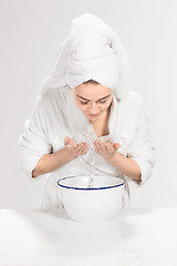 Image showing Young woman washing face with clean water