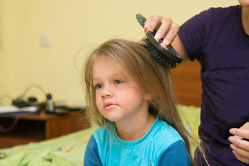 Image showing Little girl combing her long hair massage comb