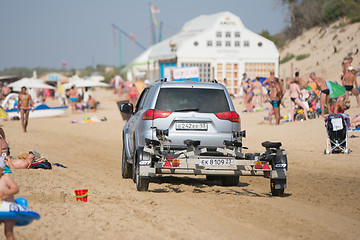 Image showing Anapa, Russia - September 20, 2015: passenger car with a trailer, riding on the beach with holidaymakers