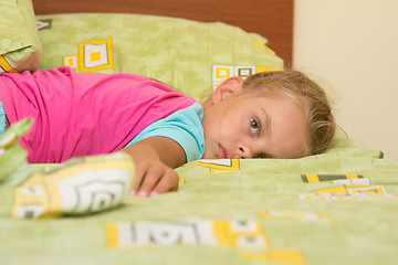 Image showing Six-year girl lying across the bed, trying to sleep