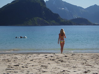 Image showing Soon testing the water temperature at the beautiful beach in Lofoten.