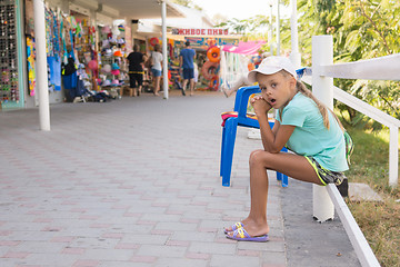 Image showing Tired girl yawning six years sat in front of stalls