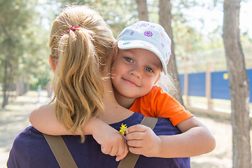 Image showing Pretty little girl is looking through my mothers shoulder while sitting in her arms