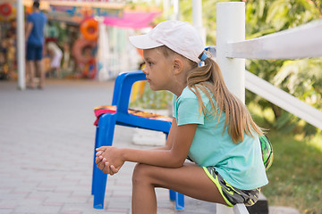 Image showing girl six years sitting in the street and waits