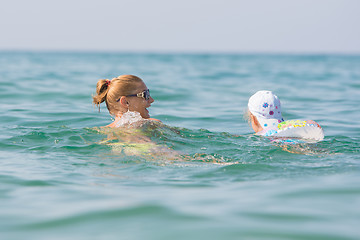 Image showing A girl with a child swimming in the sea