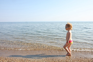 Image showing Baby girl walking on the beach sand