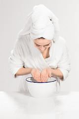 Image showing Young woman washing face with clean water