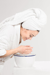 Image showing Young woman washing face with clean water