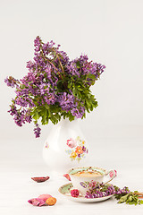 Image showing Tea with  lemon and bouquet of  lilac primroses on the table