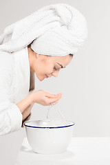 Image showing Young woman washing face with clean water