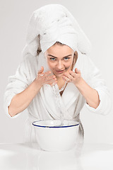 Image showing Young woman washing face with clean water