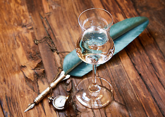 Image showing Grappa in a small glas on old wooden table