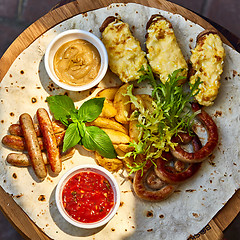 Image showing Grilled sausages and vegetables  in rustic style. 