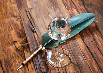 Image showing Grappa in a small glas on old wooden table