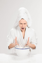 Image showing Young woman washing face with clean water