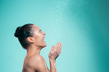 Image showing Woman enjoying water in the shower under a jet