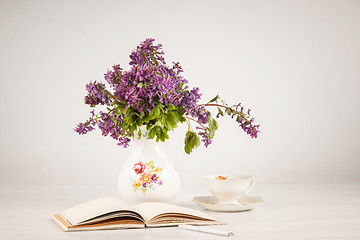 Image showing Tea with  lemon and bouquet of  lilac primroses on the table