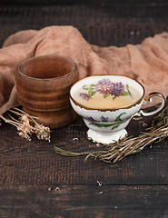 Image showing Tea with  lemon and dried flowers on the table