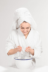 Image showing Young woman washing face with clean water