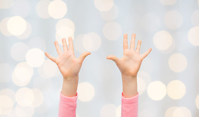 Image showing close up of little child hands raised upwards