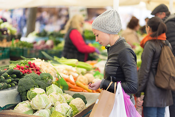 Image showing Woman buying vegetable at local food market. 