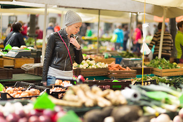 Image showing Woman buying vegetable at local food market. 