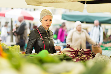 Image showing Woman buying vegetable at local food market. 