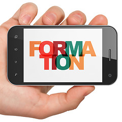 Image showing Learning concept: Hand Holding Smartphone with Formation on  display