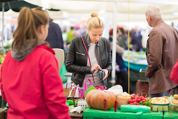 Image showing Woman buying vegetable at local food market. 