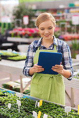 Image showing happy woman with tablet pc in greenhouse