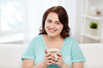 Image showing happy plus size woman with cup of tea at home