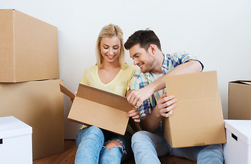 Image showing smiling couple with many boxes moving to new home