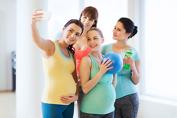 Image showing pregnant women taking selfie by smartphone in gym