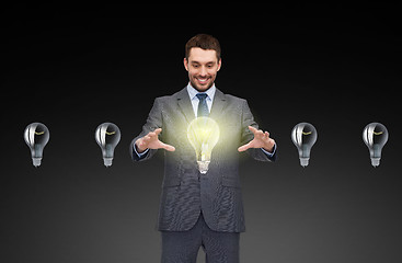 Image showing businessman working with light bulb icons